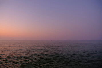 sunset over the sea in Senigallia, Marche, Italy. Natural background. Water reflections, waves in sunset lights, pink sea	
