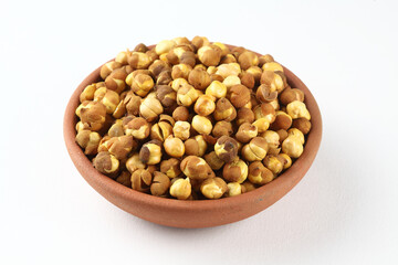 Roasted chickpeas in a terracotta bowl on a white background