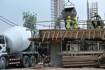 SELANGOR, MALAYSIA -MARCH 07, 2016: Concrete mixer lorry pouring liquid concrete into and the tower...