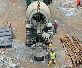SELANGOR, MALAYSIA -MARCH 07, 2016: Concrete mixer lorry pouring liquid concrete into and the tower...