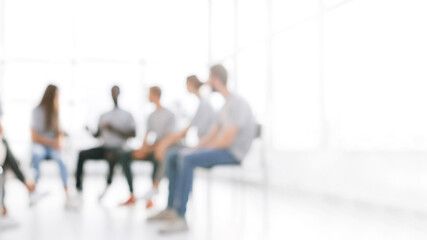 blurry image background image of a group of young people at a meeting in a conference room
