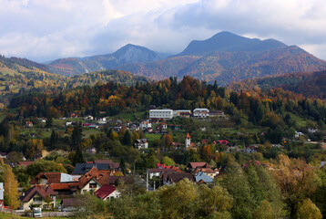 Fototapeta na wymiar Autumn landscape over Podu Dambovitei village from Rucar Bran Pass between Bucegi and Piatra Craiului.