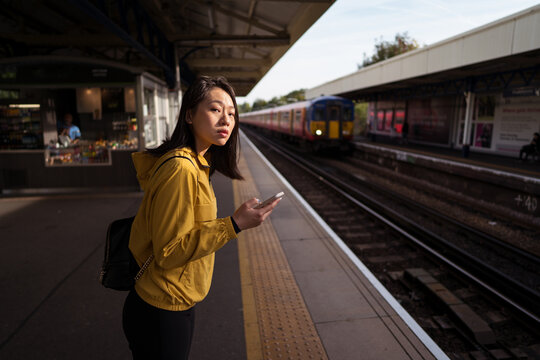 Asian woman using smartphone on railway station