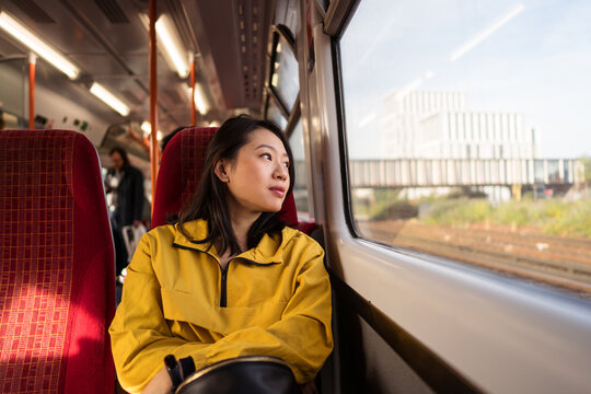 Asian woman riding train in city