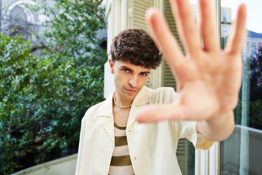 Man trying to cover camera with hand on rooftop terrace