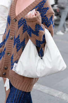 Milan, Italy - September, 23, 2022: woman wearing striped print pattern oversized wool cardigan from Missoni, white shiny leather puffy tote handbag, street style outfit details