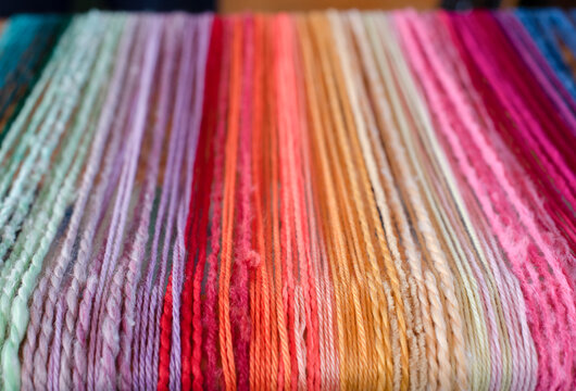 Rows of multicolored threads on loom