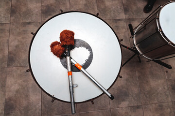 percussion mallets resting on a drum head in an interior