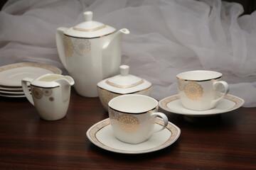 Fototapeta premium White tea set on a white background. Teapot, cups, plates