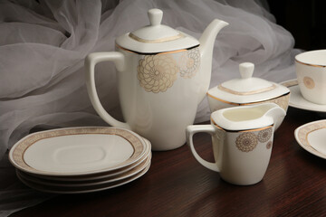 White tea set on a white background. Teapot, cups, plates