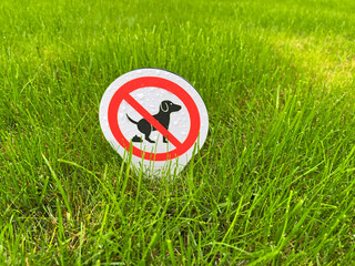 Sign banning dog excrement on a green gras meadow