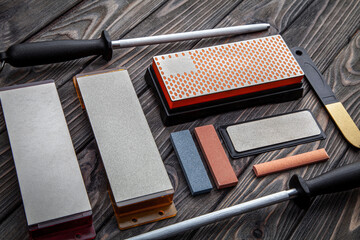 A variety of knife sharpeners. Sharpening stones and devices on a wooden background. Grinding stones