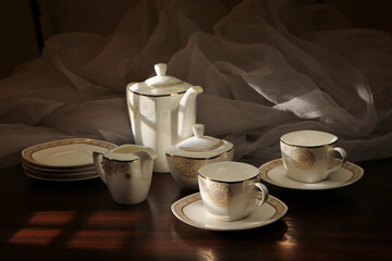 White tea set on a white background. Teapot, cups, plates