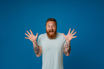 Adult bearded tattooed handsome stylish enthusiastic man with opened mouth,