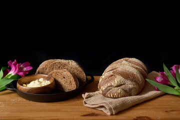 Brown bread slices on wooden table. Dark composition. Bakery concept.