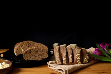 Decorated brown bread on wooden table. Dark composition. Copy Space. Bakery concept.