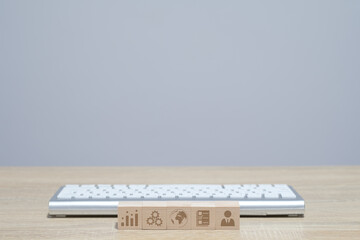 Keyboard and wooden cube with business icon employee, data, global, gear and trade graph. efficient work and success concept