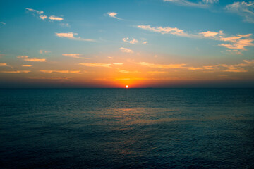 Seascape in early morning, sunrise over sea. Nature landscape. sunshine over the horizon with blue cloudy sky