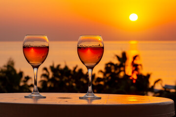 Two glasses of wine and tropical sea sunset