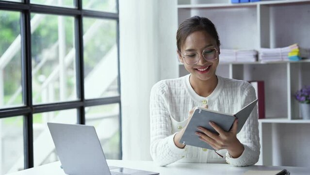 Asian businesswoman working on laptop computer About happy business projects sitting at your desk at home.