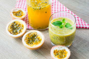 Passion fruit smoothie by fresh ingredients with slice passion fruit on wooden table.