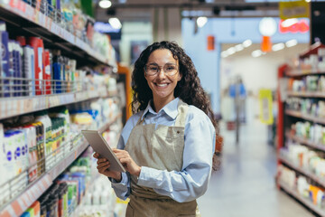 Portrait of happy and successful saleswoman, hispanic woman with curly hair smiling and looking at...