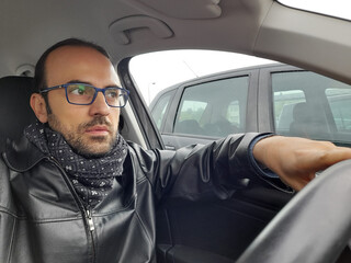 Autista in giro per la città nel traffico in autunno