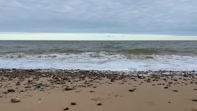 Waves crashing onto the beach with a dramatic cloudy sky background. Timelapse video footage taken in Lowestoft England. 