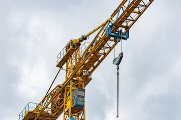 Close up to a construction crane cabin for manual operations with hook and chain for heavy lifting