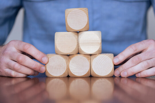 Close up of a business person arranging large wooden blocks. Business strategy and solutions
