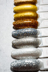 Samples of nail polish in different bright colors with sequins. Colorful manicure samples with nail polish. Top view of the palette of gel lacquers for nail art.