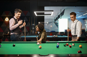 Friends enjoying billiard game at pool hall