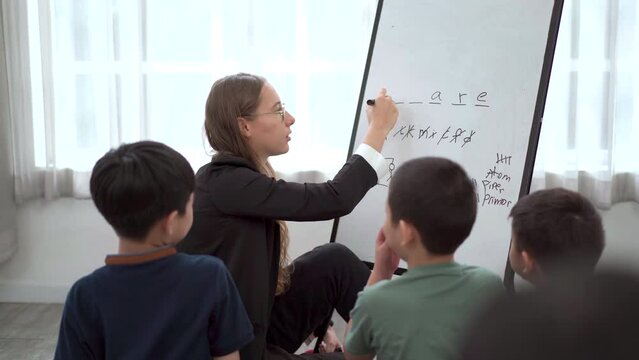 Teacher playing a hangman and crosswords with little children.