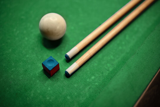 Closeup cue, ball and chalk on billiard table