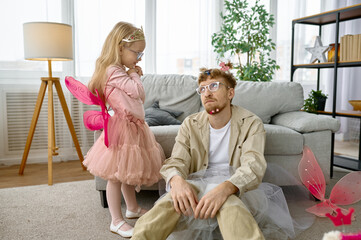 Tired father wearing having fun with daughter