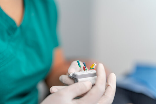 Crop stomatologist holding tool with barbed broaches in clinic
