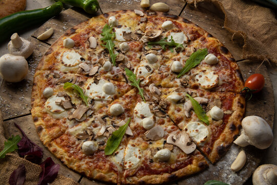 Traditional italian food. Delicious fresh pizza with cheese,  and onion on wooden background with ingredients, flat lay.