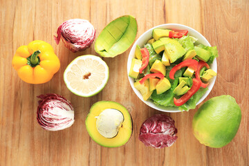 Top view of green salad with fruit and  vegetables on wooden table  background