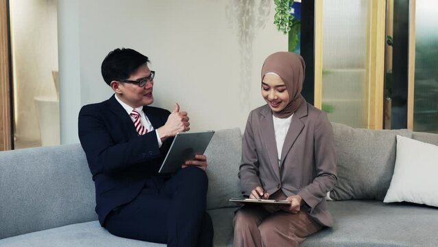 Male professional mentor helping female client teach intern training new worker consult  customer explain online business services. male and female sitting on sofa working discussing project together 