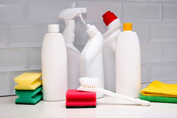 Household cleaning products in white plastic bottles are on the table. The concept of household...