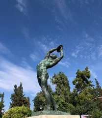 Foto op Plexiglas Historisch monument Verticale opname van het standbeeld van Discobolus voor het Panathenaic Stadion in Athene, Griekenland