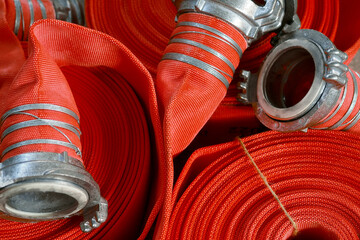 View of many twisted red fire hoses close-up in full screen. New fire extinguishing equipment....