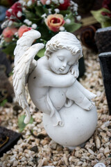 closeup of stoned angel sitting on tomb at the cemetery