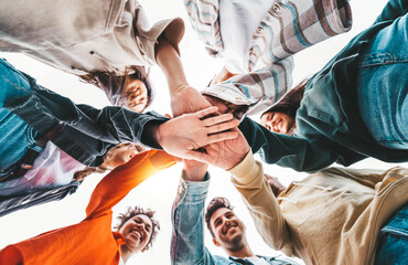 Community of young people stacking hands together - Multiracial college students putting their...