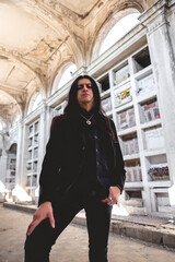 Dark gothic tall man with long hair in large ancient abandoned mausoleum in neoclassical style with...