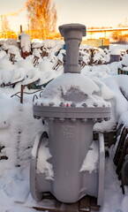 Old large water valves covered with snow in winter
