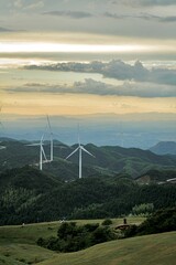 Vertical shot of the industrial windmills on the hills