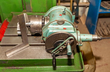 The dividing head in close-up on the bed of the drilling machine in the mechanical assembly shop of...