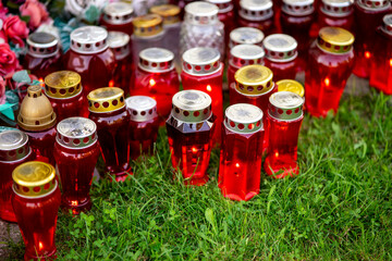 lighting a red candle for the day of the dead in a small village in Croatia