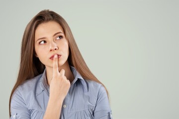 Serious dreaming young woman posing